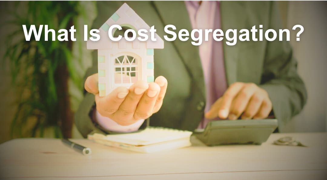 What Is Cost Segregation? — a person in a suit holding a small model house beside a calculator, illustrating cost segregation tax analysis for a short-term rental